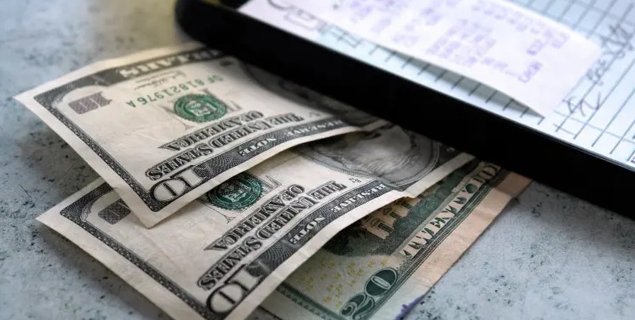 Долларовые купюры и расчетный лист, иллюстрирующие расследование незаконных выплат госслужащему
