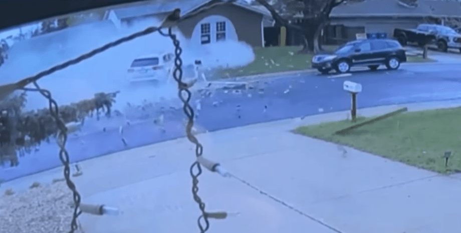 Кадр с камеры наблюдения, запечатлевший столкновение автомобиля с домом на улице в городе Аврора, штат Колорадо
