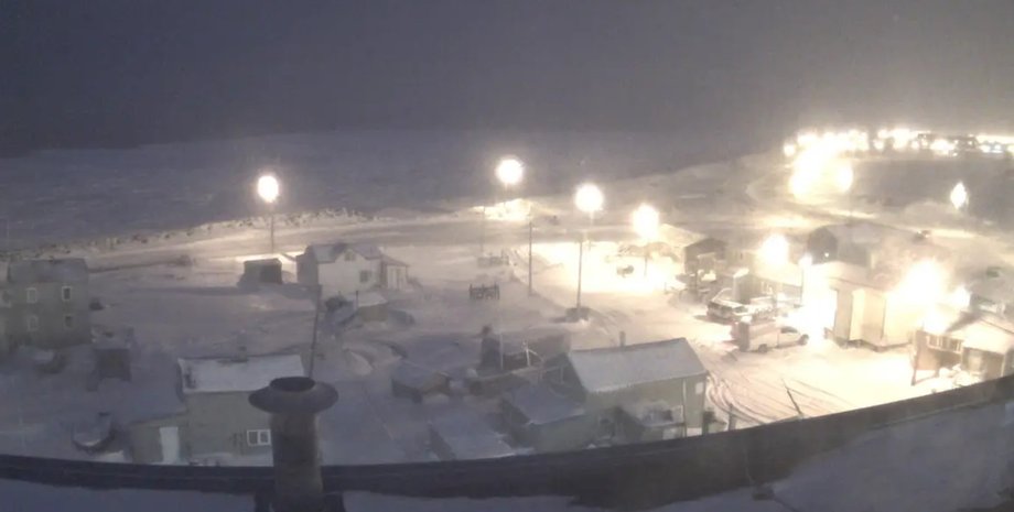 Уткиагвик зимой во время полярной ночи, заснеженные дома и улицы, освещенные фонарями на фоне темного неба