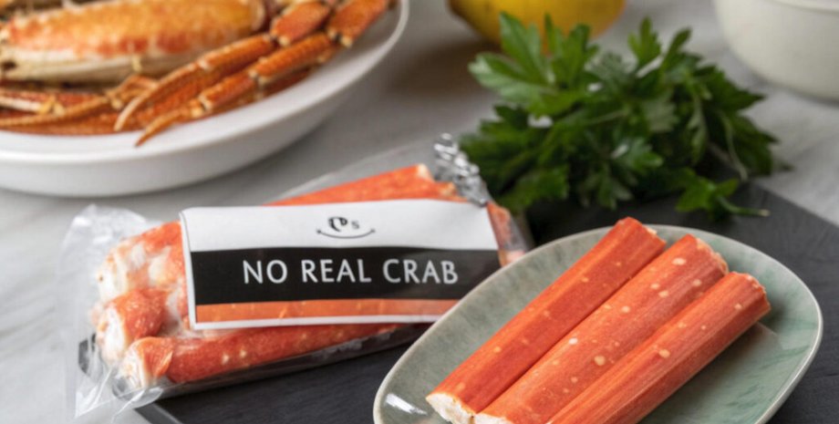 Упаковка крабовых палочек с надписью «No real crab» и тарелка с палочками на кухонном столе