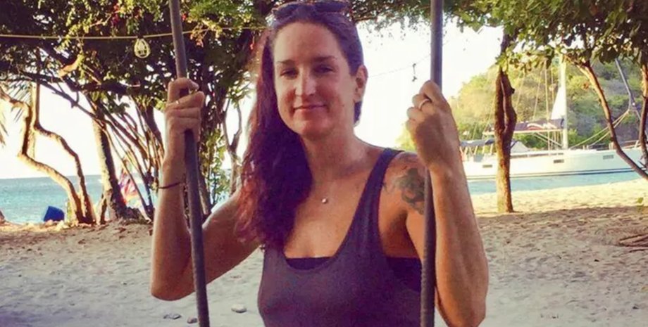 Сарм Хеслоп улыбается и управляет яхтой на фоне моря