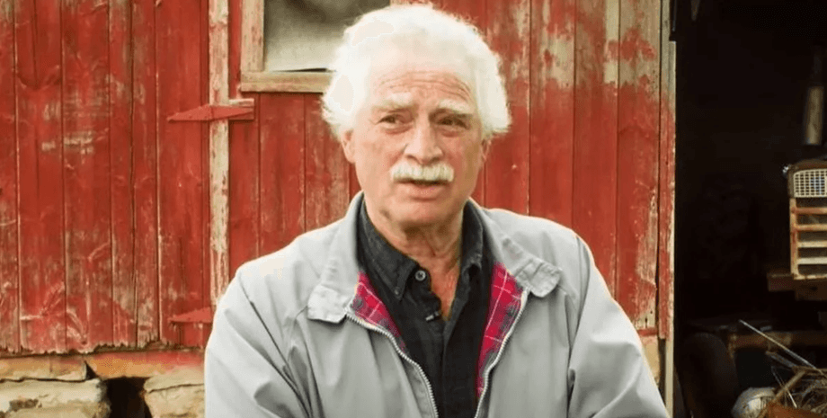 Филип Хашейдер стоит у старого красного амбара, рассказывая о пережитом опыте клинической смерти