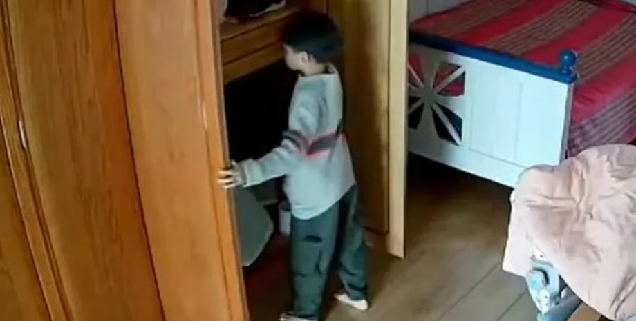 Мальчик из Китая открывает мамин шкаф перед тем, как взять золотое ожерелье