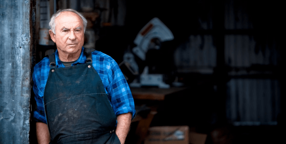 Ивон Шуинар в рабочем фартуке стоит у входа в мастерскую