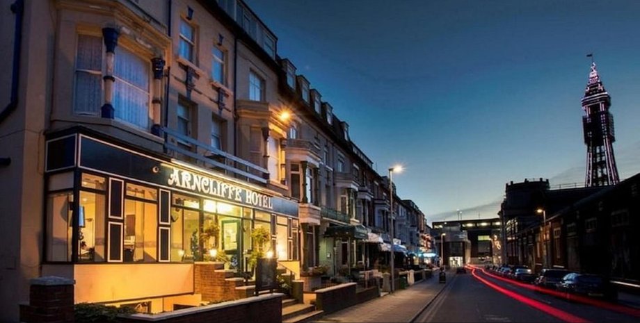 Фасад отеля Arncliffe в Блэкпуле на фоне вечернего неба с видом на башню Blackpool Tower