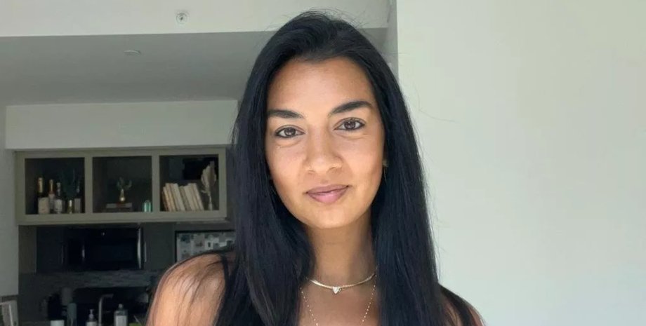 Модель с длинными темными волосами и естественным макияжем улыбается